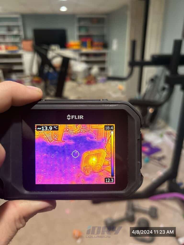 Thermal imaging camera detecting water damage in a cluttered basement