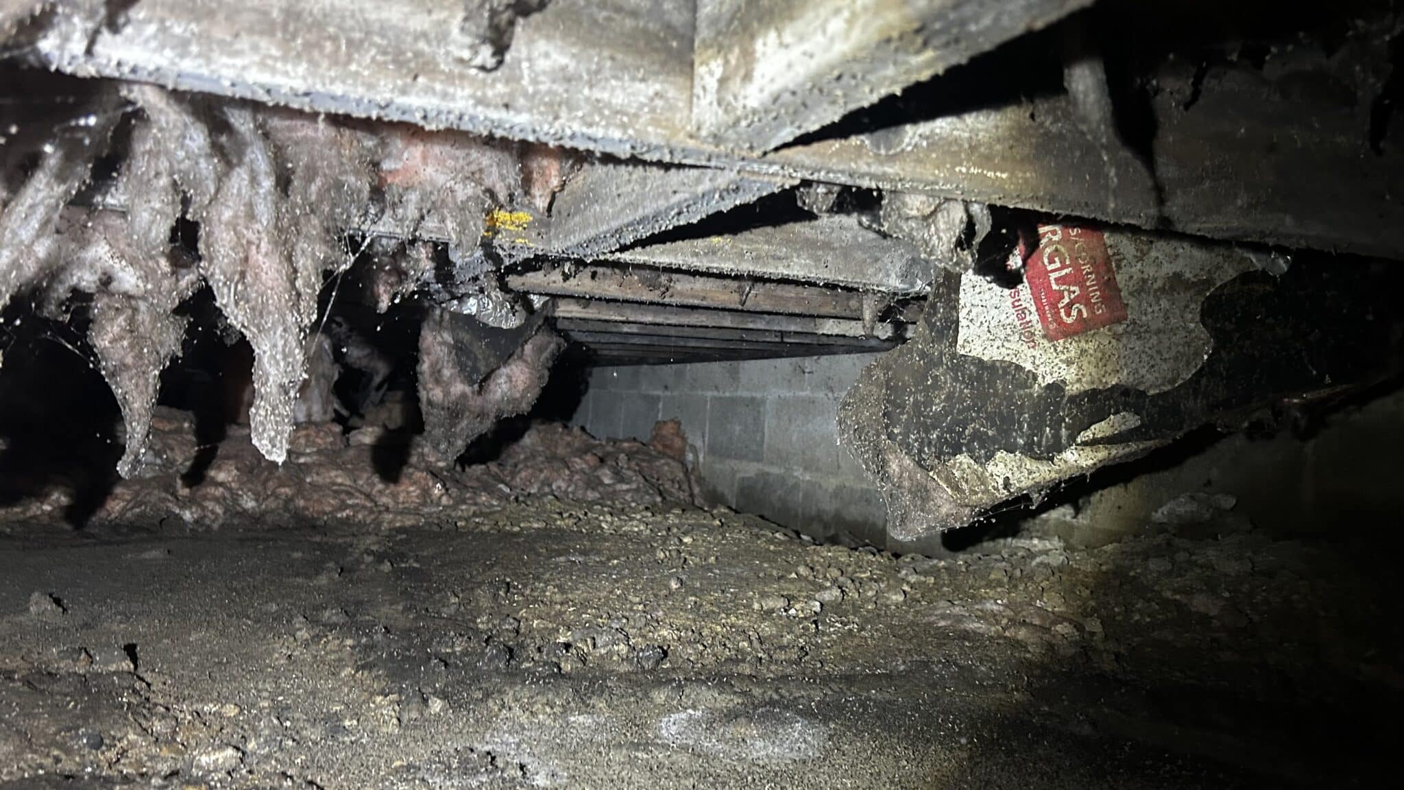 Before — severely deteriorated hanging insulation and mold damage across floor joists in Columbus crawl space prior to iDry remediation