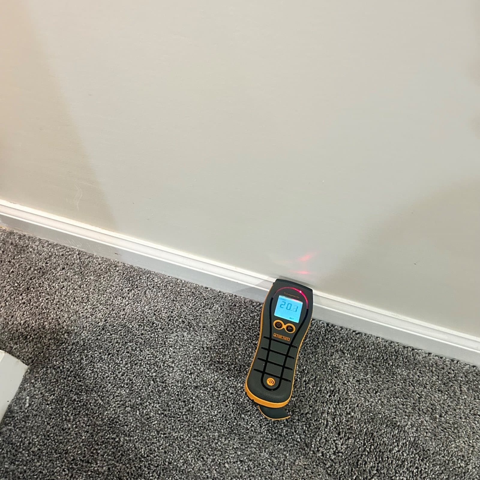 Moisture meter reading on wet carpet during water damage assessment